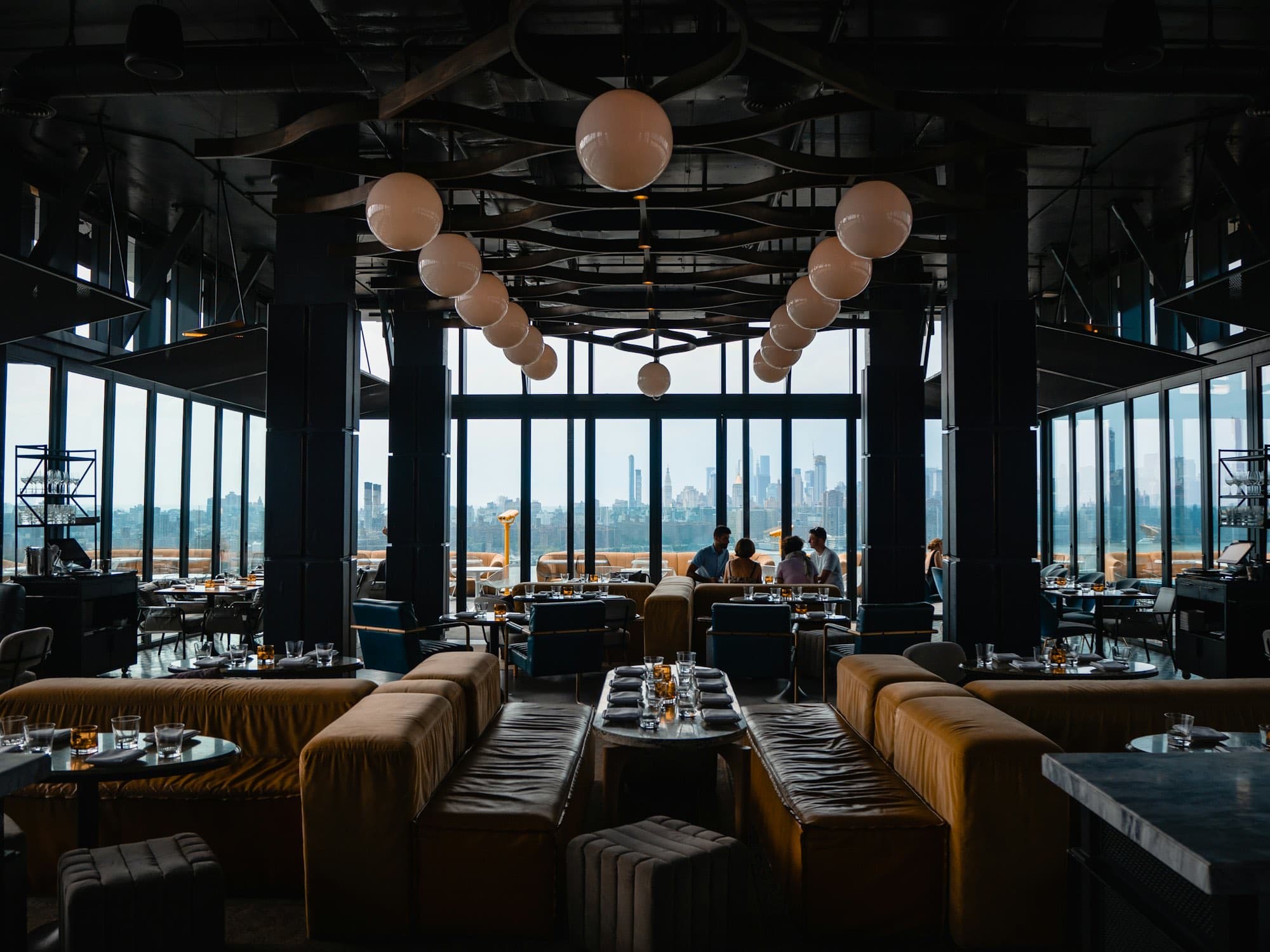 A restaurant dining room at dusk with a view over the city