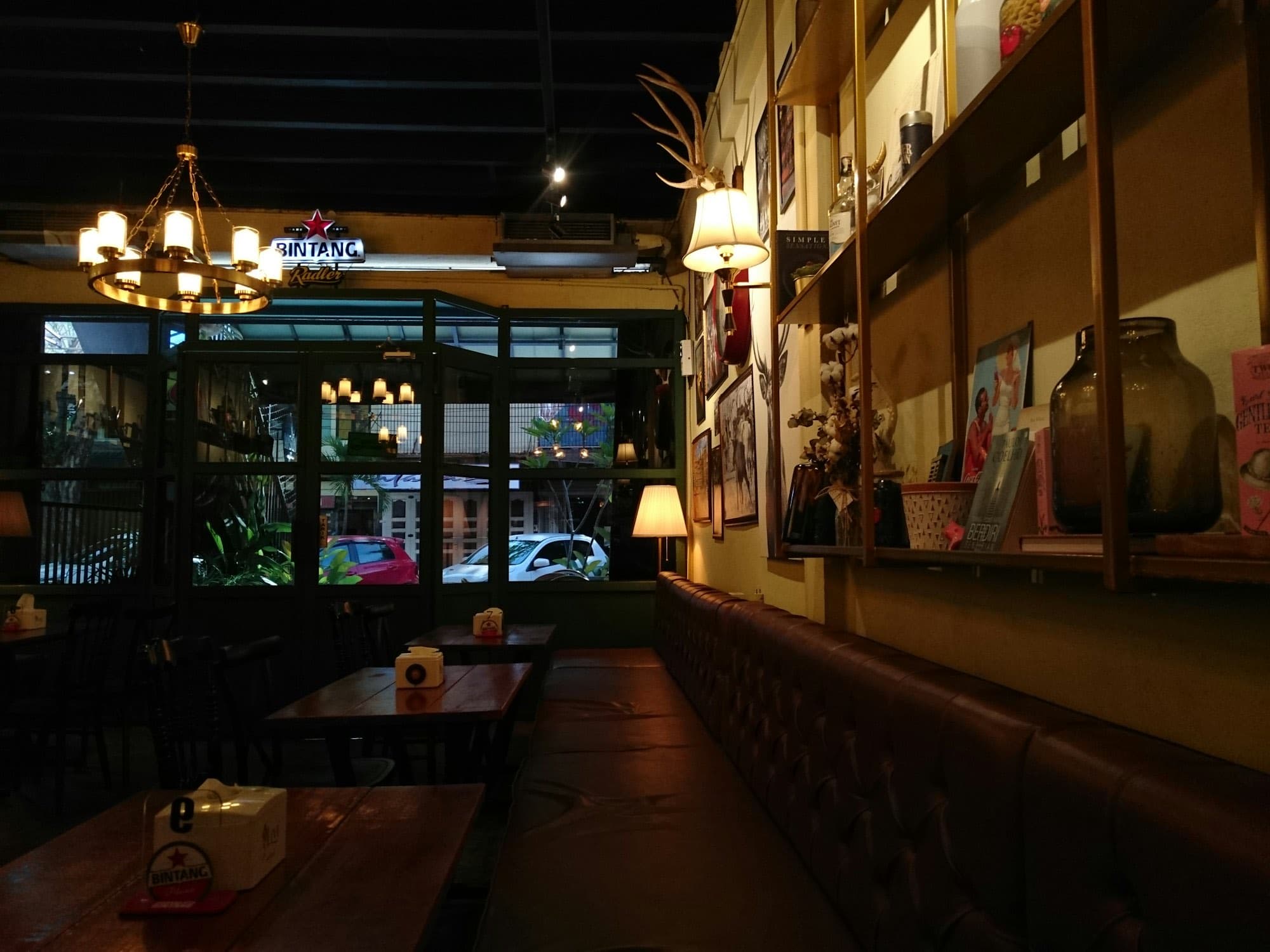 A candlelit dining room with dark panelling and artwork