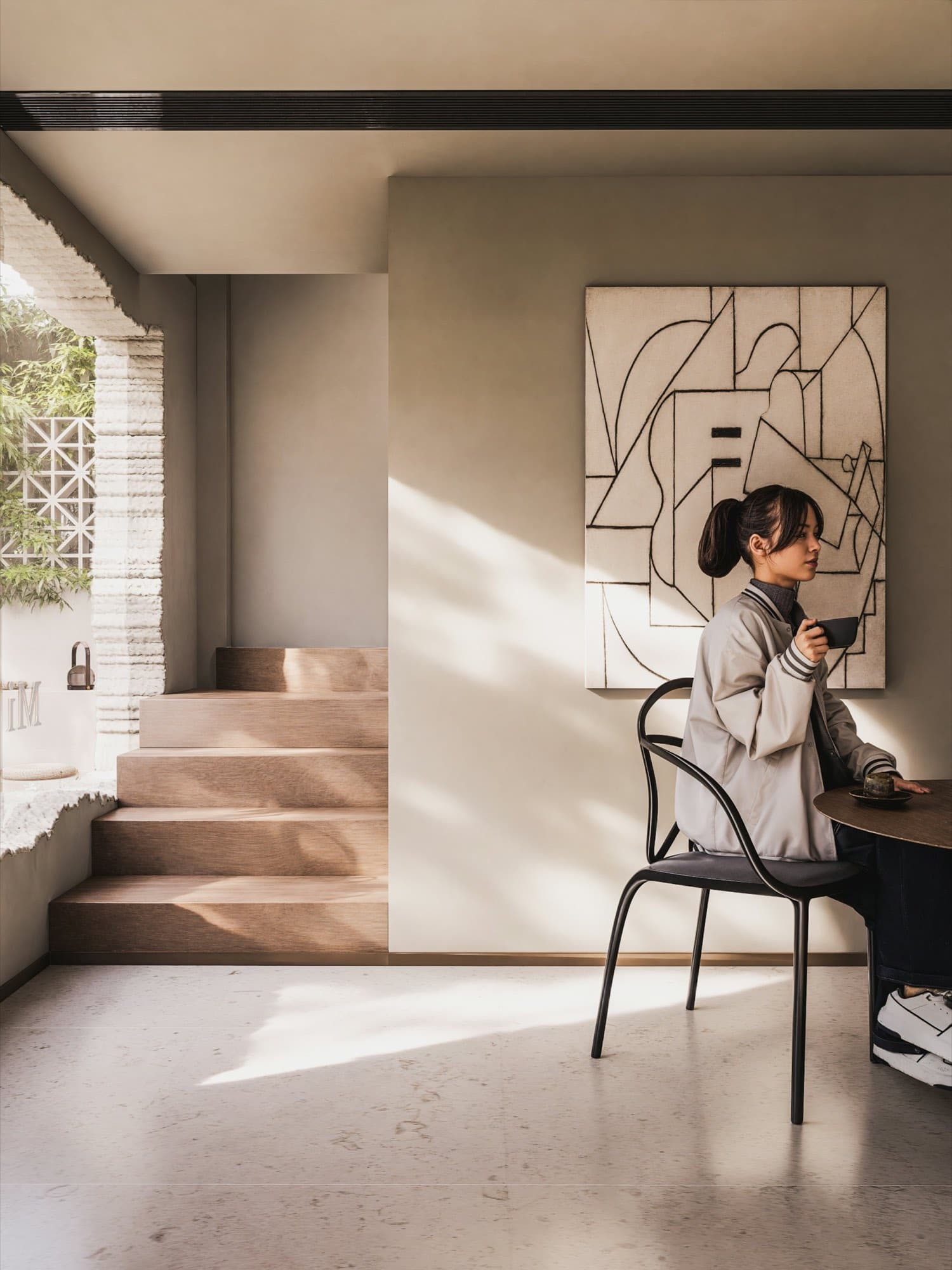 A person working at a desk in a warm, sparsely furnished room