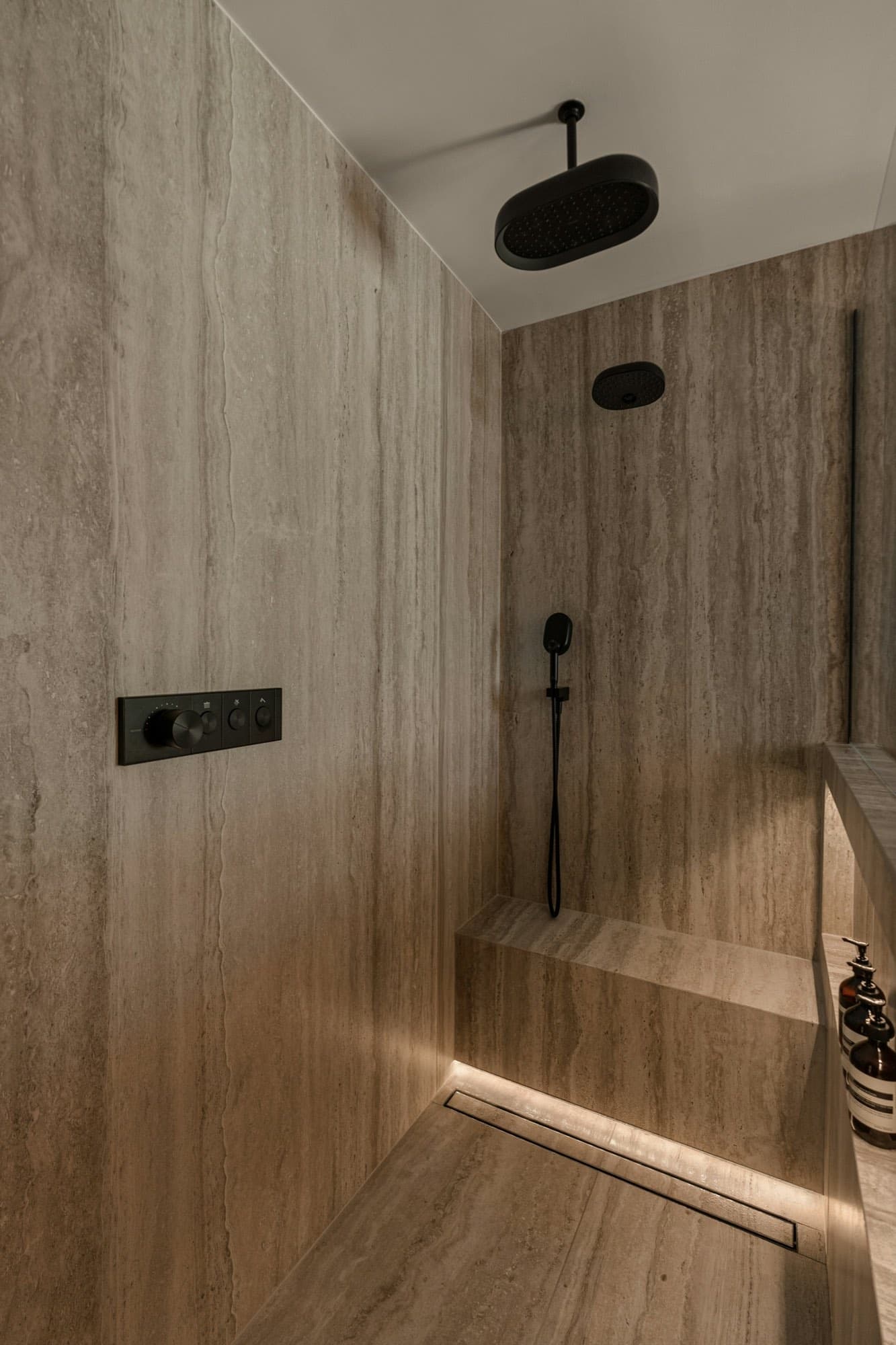 A detail of travertine wall cladding and dark fittings