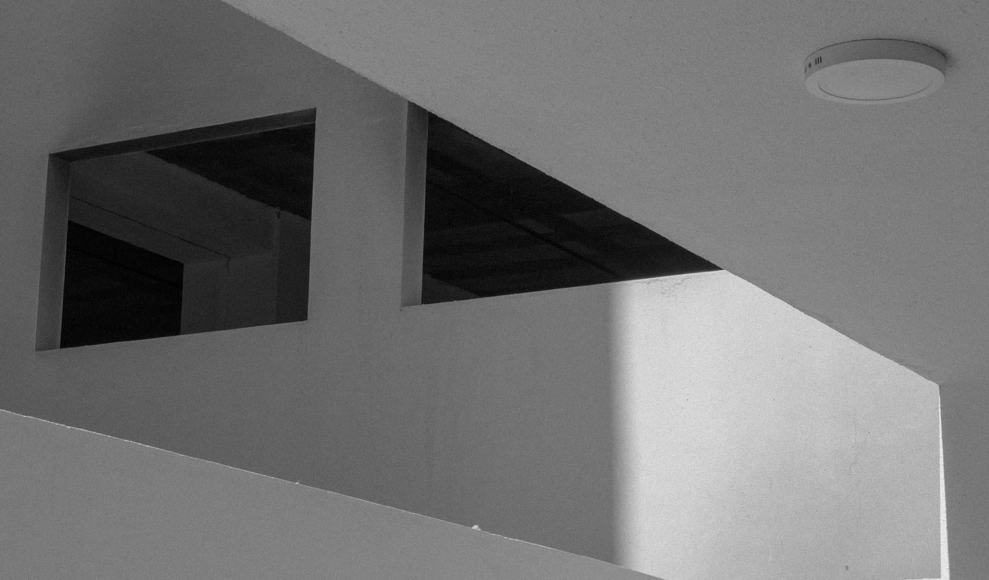 A white ceiling with sharp geometric openings