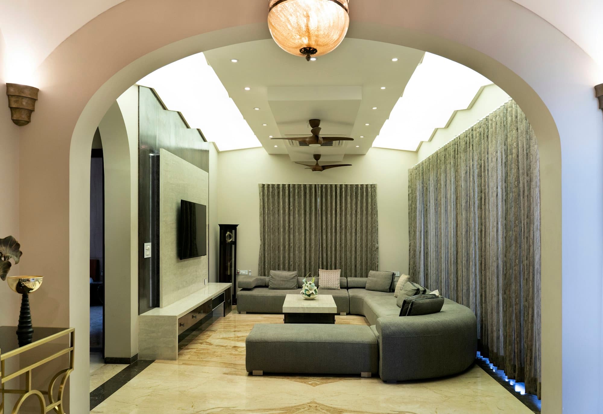 A living room framed by a wide arch, opening onto daylight